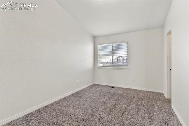 carpeted empty room featuring lofted ceiling, visible vents, and baseboards