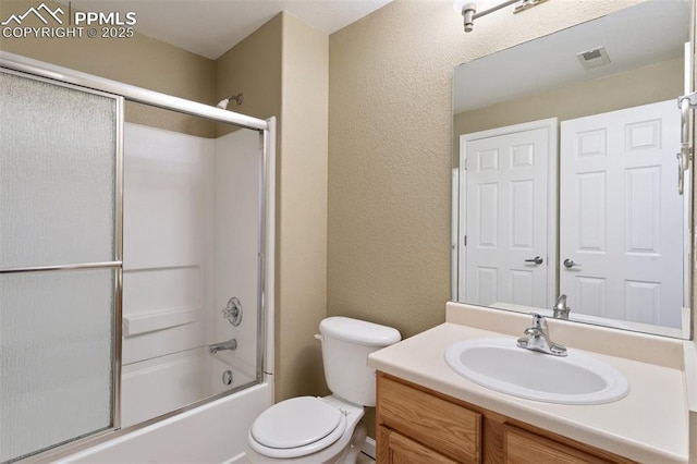 full bathroom with a textured wall, toilet, shower / bath combination with glass door, vanity, and visible vents