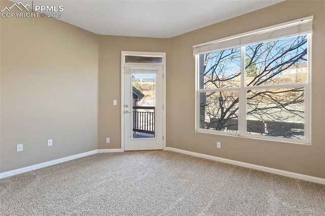 carpeted empty room featuring baseboards