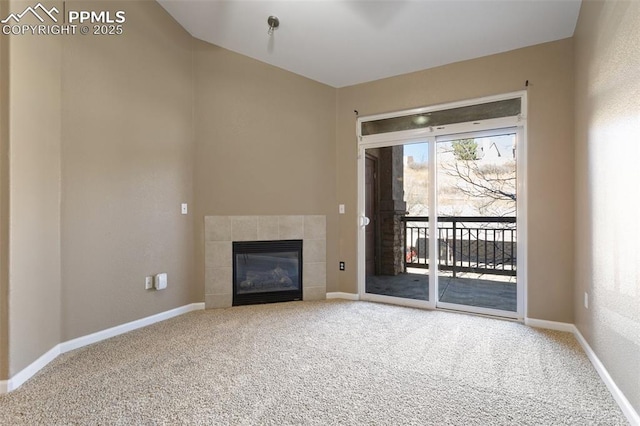 unfurnished living room with baseboards, carpet flooring, and a tile fireplace