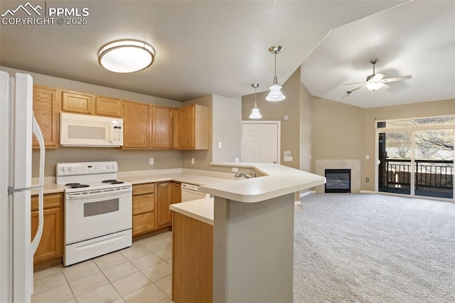 kitchen featuring white appliances, open floor plan, a peninsula, hanging light fixtures, and light countertops