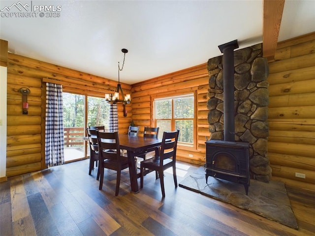 dining area with a healthy amount of sunlight, a wood stove, log walls, and dark hardwood / wood-style flooring