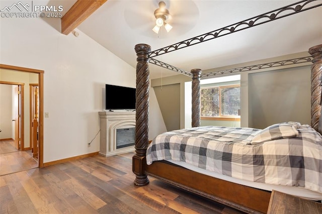 bedroom with hardwood / wood-style flooring, ceiling fan, and vaulted ceiling with beams