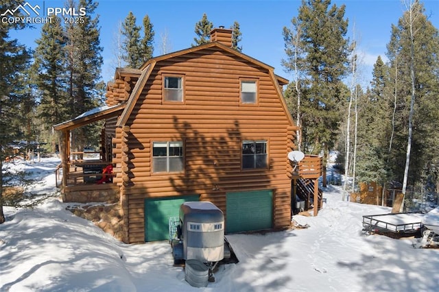 view of snow covered exterior with a deck and a garage