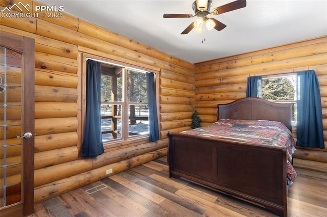 bedroom with hardwood / wood-style flooring and rustic walls