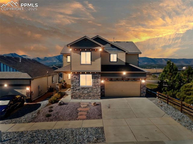 view of front of property featuring an attached garage, fence, driveway, and a mountain view