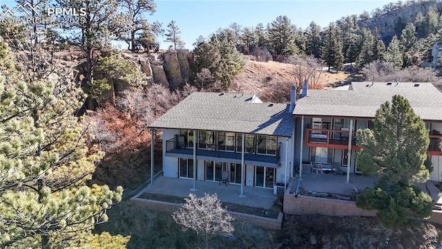 rear view of property featuring a patio and a balcony