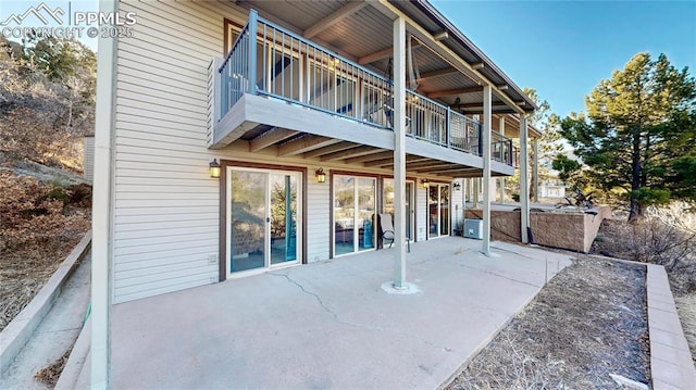 rear view of house with a balcony, a patio area, and a jacuzzi