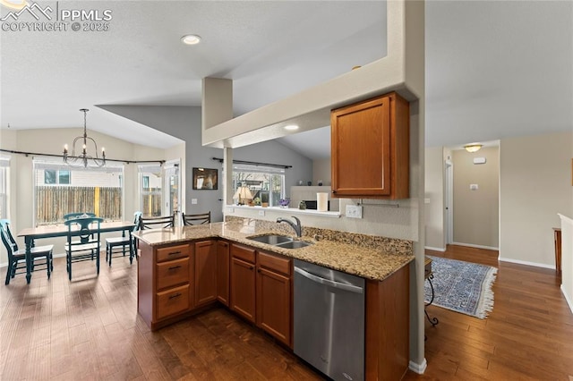 kitchen featuring brown cabinetry, lofted ceiling, a sink, and dishwasher