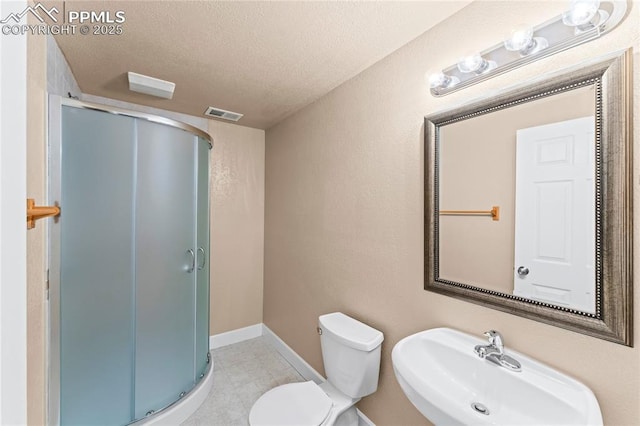 full bathroom featuring a sink, visible vents, a shower stall, a textured ceiling, and toilet