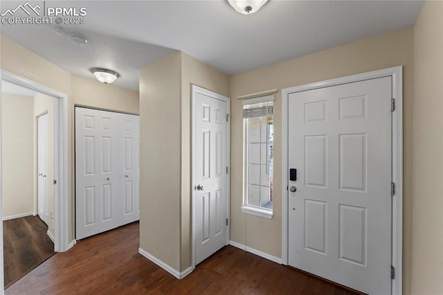 entrance foyer featuring baseboards and dark wood-style floors