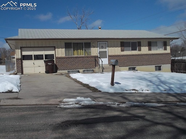 2106 Capulin Dr, Colorado Springs, CO 80910 - view of front facade featuring an attached garage, brick siding, and driveway