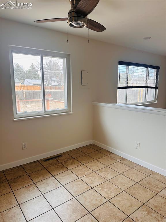 tiled empty room featuring ceiling fan