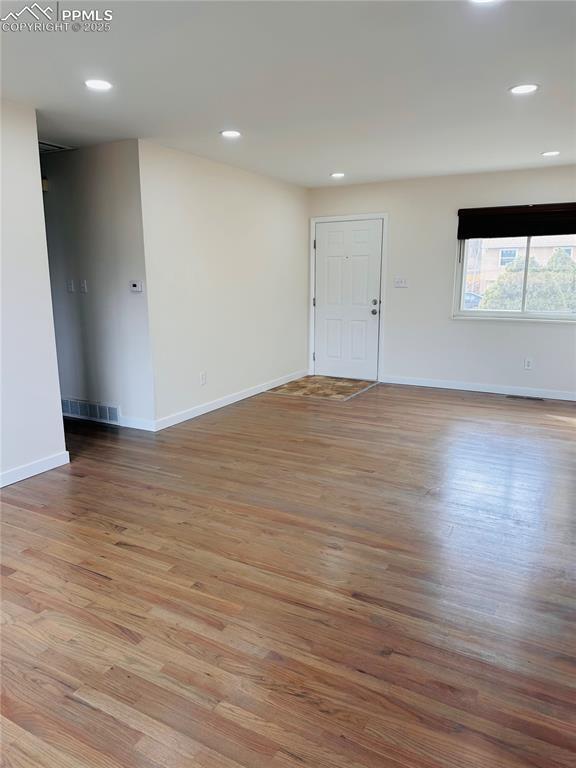 empty room with light hardwood / wood-style flooring