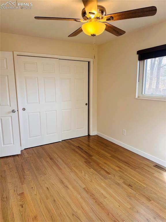 unfurnished bedroom featuring a closet, ceiling fan, and light wood-type flooring