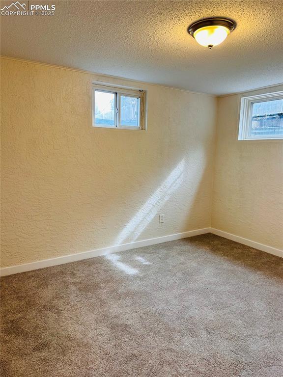 basement featuring carpet flooring and a textured ceiling