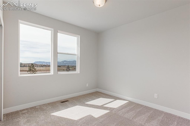 carpeted empty room featuring a mountain view