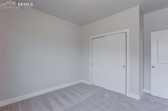 unfurnished bedroom with light carpet and a closet