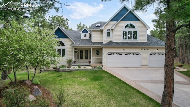 view of front of property with driveway, a shingled roof, an attached garage, french doors, and a front yard