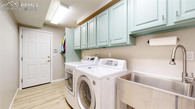 laundry room featuring cabinets, light hardwood / wood-style flooring, sink, and separate washer and dryer