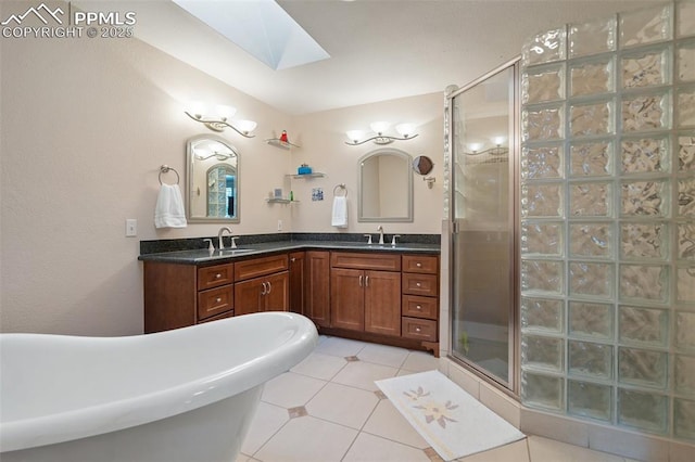 bathroom with tile patterned flooring, a skylight, plus walk in shower, and vanity