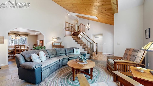 living area featuring a chandelier, a high ceiling, wood ceiling, baseboards, and stairs