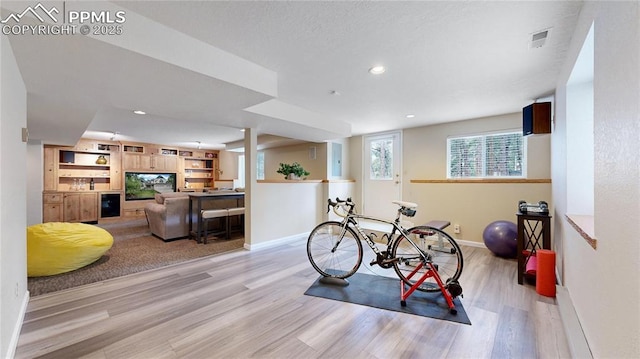 exercise room with light hardwood / wood-style flooring