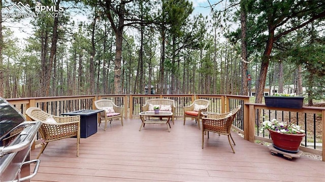 deck with an outdoor living space with a fire pit