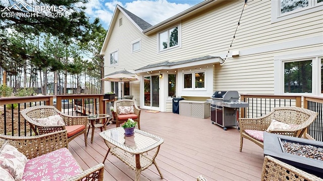 deck featuring a grill and an outdoor living space with a fire pit