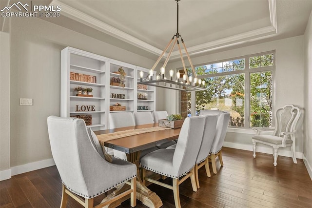 dining area with a notable chandelier, ornamental molding, a raised ceiling, and dark hardwood / wood-style floors