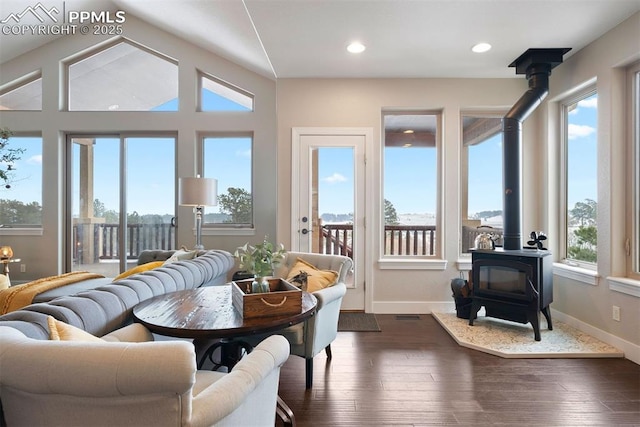 sunroom featuring a wood stove and vaulted ceiling