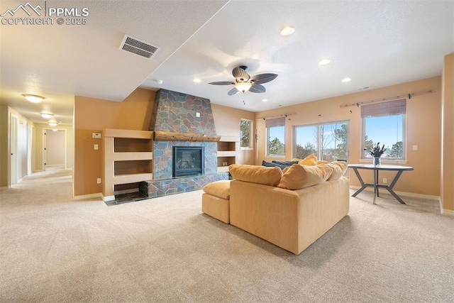 carpeted living room featuring a fireplace and ceiling fan