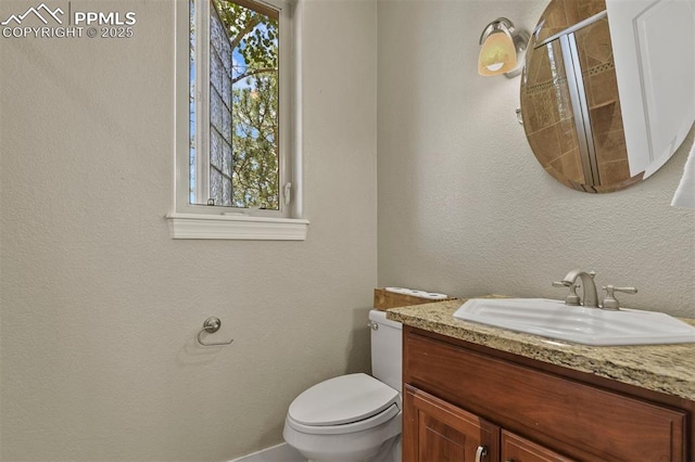 bathroom with vanity, toilet, and walk in shower