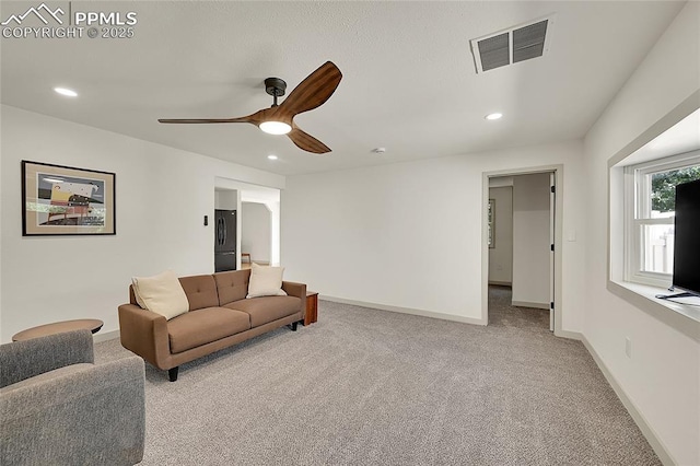 carpeted living room featuring a ceiling fan, recessed lighting, visible vents, and baseboards