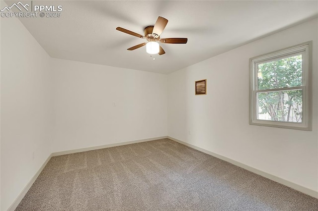 spare room with a ceiling fan, light carpet, and baseboards