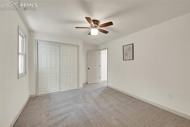 unfurnished bedroom with carpet floors, a closet, ceiling fan, and baseboards