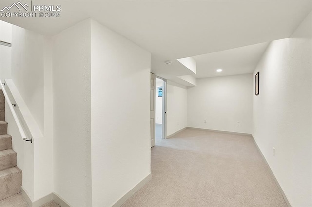 finished basement with light colored carpet, baseboards, and stairs