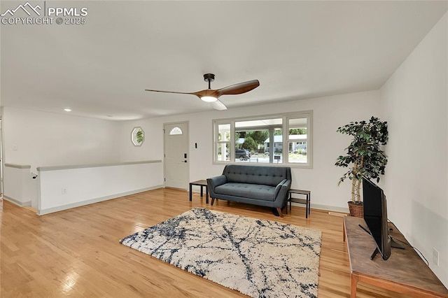 interior space with a ceiling fan, light wood-style flooring, and baseboards