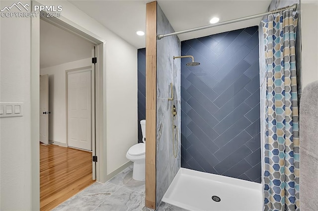 full bathroom featuring toilet, a stall shower, and baseboards
