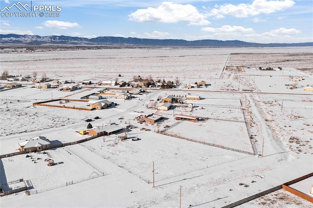 snowy aerial view with a mountain view