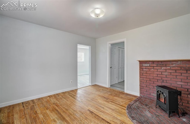 unfurnished living room with light wood-type flooring and a wood stove