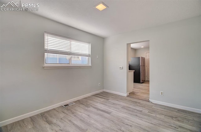 unfurnished room with light wood-type flooring