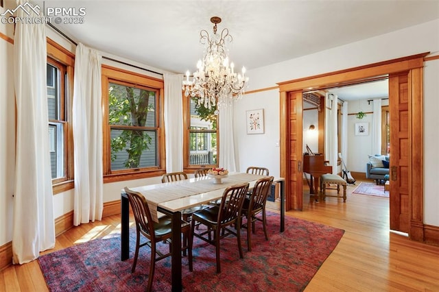 dining room with light wood-style floors, baseboards, and a chandelier