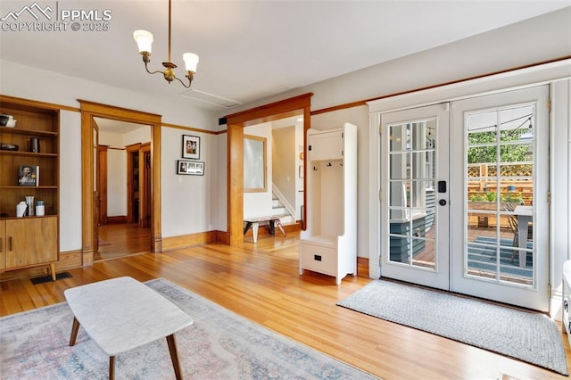 interior space with light wood finished floors, visible vents, stairs, french doors, and a chandelier