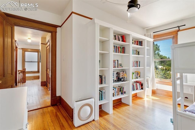 corridor with light wood finished floors and baseboards