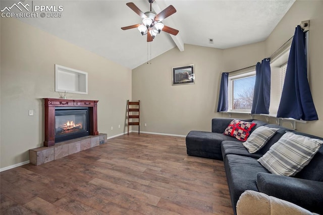 living area with a tile fireplace, lofted ceiling with beams, baseboards, and wood finished floors