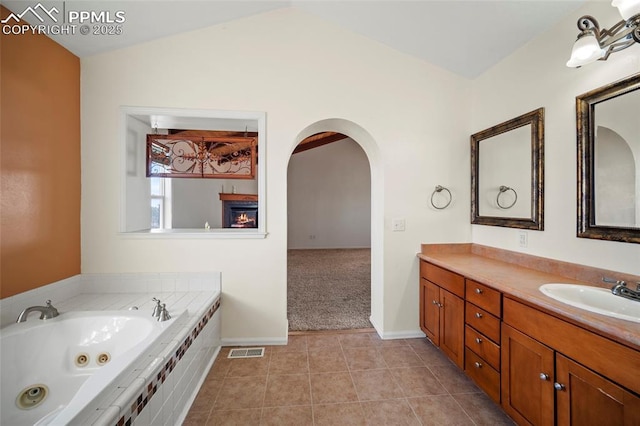 full bathroom with lofted ceiling, visible vents, vanity, tile patterned flooring, and a whirlpool tub