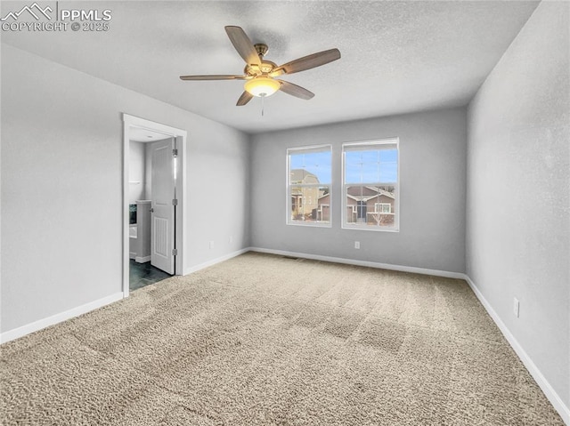 unfurnished bedroom featuring a textured ceiling, ceiling fan, ensuite bathroom, carpet flooring, and baseboards