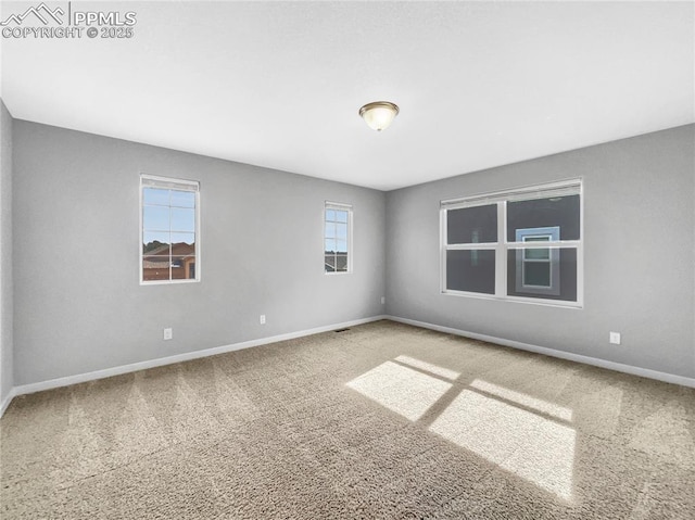 empty room with baseboards and carpet flooring