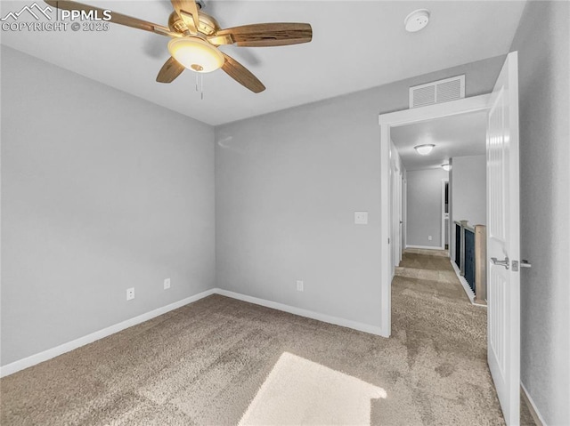 spare room with baseboards, ceiling fan, visible vents, and light colored carpet